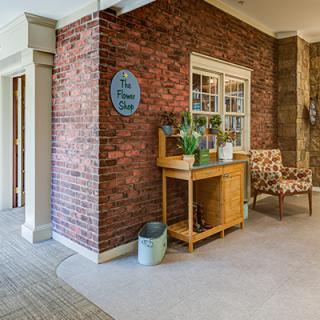 A cozy interior space featuring a brick wall, decorated with indoor plants and comfortable seating.