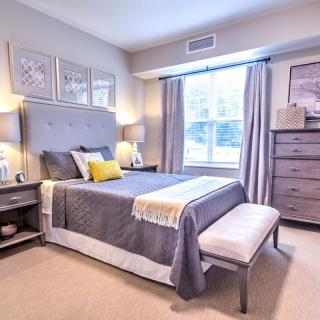 A modern and cozy bedroom with stylish decor, featuring a comfortable bed, matching furniture, and soft lighting.