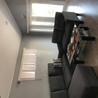 A modern living room with a grey sofa set and a glass coffee table.
