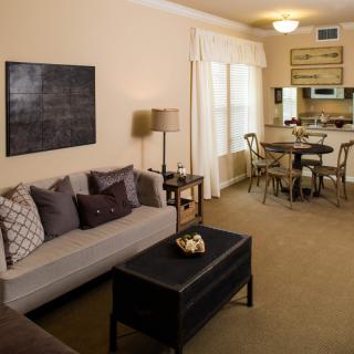 A cozy living room with a comfortable sofa, coffee table, and adjacent dining area.