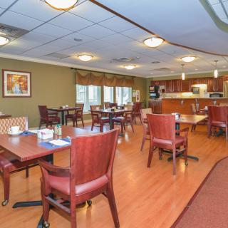 A spacious and well-lit dining area with wooden furniture and a warm, inviting atmosphere.