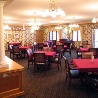An elegantly decorated dining room with red tablecloths and stylish chairs.
