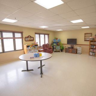 A spacious classroom equipped with desks and chairs, designed for educational activities.