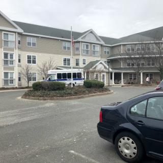 A view of a residential building with a parked van in the foreground.