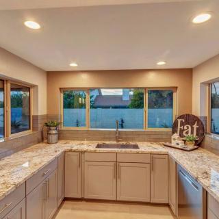 A modern kitchen with spacious countertops and ample natural light from large windows.