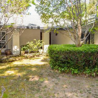 A house with a garden featuring trees and shrubbery.