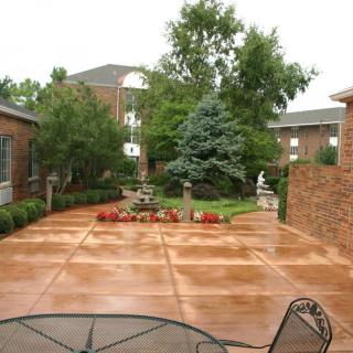 A serene courtyard with a well-maintained garden and patio area surrounded by buildings.
