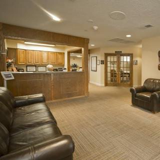 A cozy waiting room with leather sofas and a reception desk.