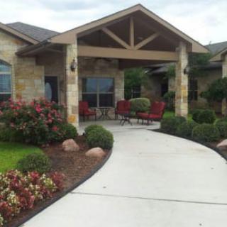 A beautiful house entrance with a landscaped garden and pathway leading to the patio.