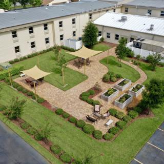 Aerial view of a landscaped courtyard with walkways, benches, and greenery surrounded by buildings.