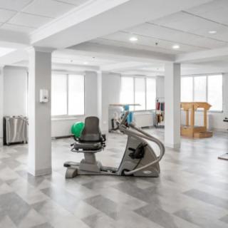 A modern, well-lit gym featuring various exercise equipment.