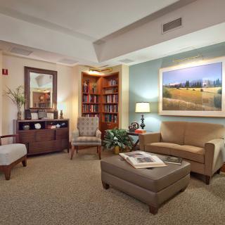 A cozy living room with comfortable seating, a bookshelf, and warm lighting.