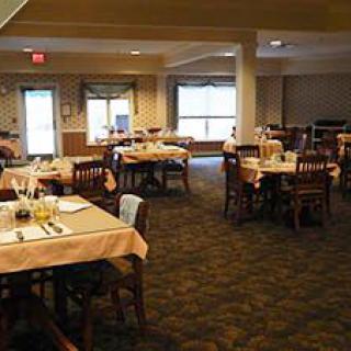 An empty restaurant dining area with neatly set tables and chairs.