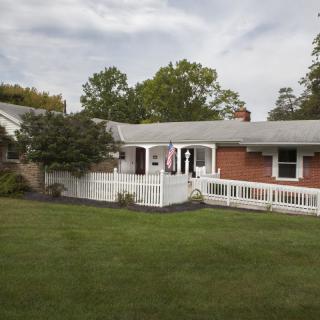 A suburban house with a spacious front lawn and surrounding trees.