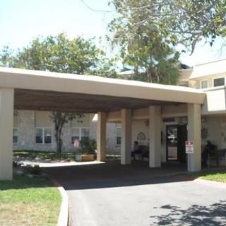 A building entrance with a covered walkway and surrounding trees.