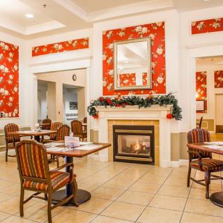 A cozy dining area with festive holiday decorations and a warm fireplace.