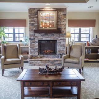 A cozy living room featuring a stone fireplace and comfortable armchairs.