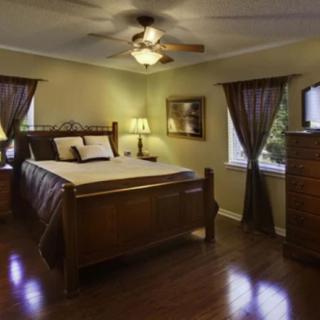 A cozy bedroom featuring wooden furniture and a ceiling fan.