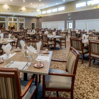 An elegant dining hall with neatly arranged tables and chairs, prepared for guests.