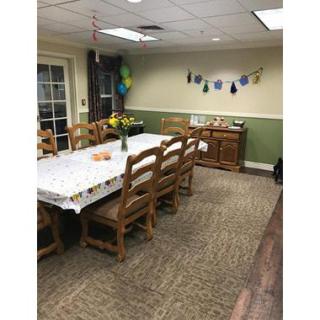 A decorated dining room with a long table and chairs prepared for a celebration.