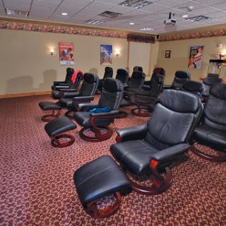 A cozy home theater featuring comfortable recliner chairs arranged for an optimal viewing experience.