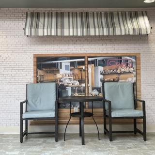 Outdoor seating arrangement with two chairs and a table in front of a cafe storefront.