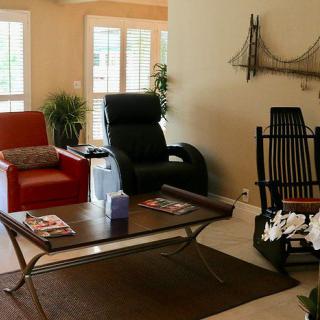 A cozy living room featuring a variety of chairs and a coffee table in a warm, inviting atmosphere.