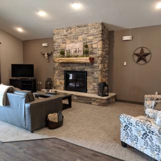 A cozy living room featuring a stone fireplace and comfortable seating.