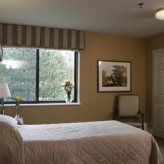 Cozy bedroom with a large window and simple decor.