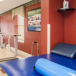 A rehabilitation room equipped with exercise equipment and a therapy mat.