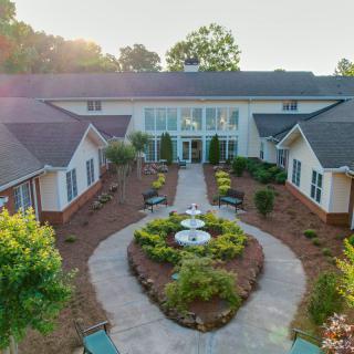 A landscaped courtyard with pathways leading to a large building.