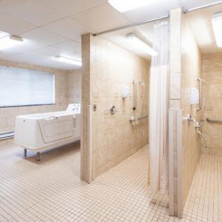A clean and modern bathroom featuring multiple shower stalls and a laundry area.