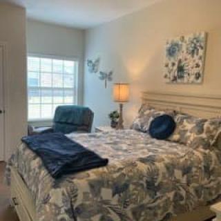 A cozy bedroom with floral bedding and soft lighting.