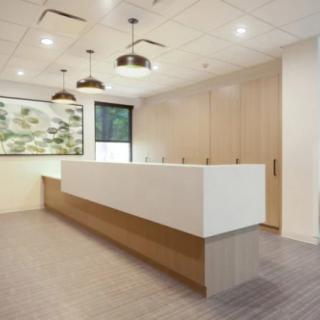 A modern and minimalist office reception area with sleek furniture and contemporary lighting.