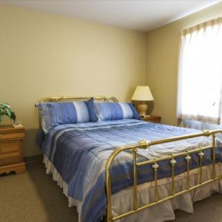 A cozy bedroom with a brass bed frame and blue bedding.