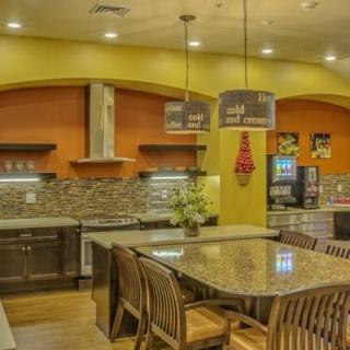 A modern kitchen with a central island countertop and stylish lighting fixtures.