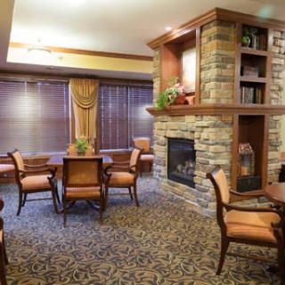 A cozy living room with a stone fireplace and comfortable seating arrangements.