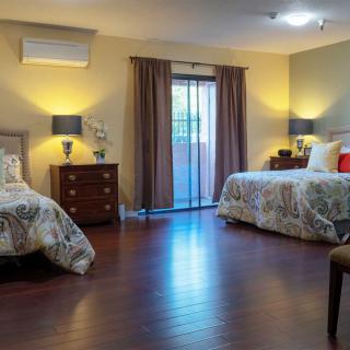 A cozy bedroom with two beds, nightstands, and soft lighting.