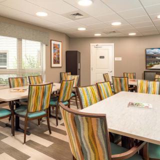 A modern conference room with striped upholstered chairs and large tables, suitable for meetings or group discussions.