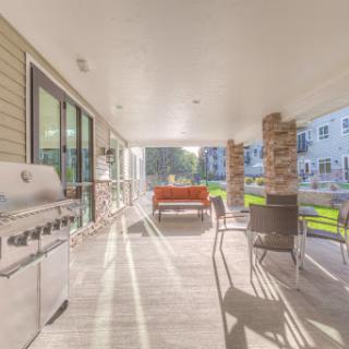 A spacious outdoor patio featuring a grill and comfortable seating, perfect for gatherings.