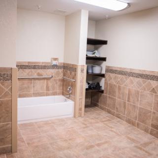 A spacious and modern bathroom featuring a bathtub and tiled walls.
