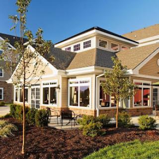 A beautifully designed residential building with large windows and landscaped surroundings.