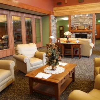 A cozy living room with comfortable seating, a fireplace, and a wooden table.