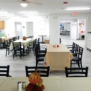 A community dining area with neatly arranged tables and chairs, adorned with festive decorations.
