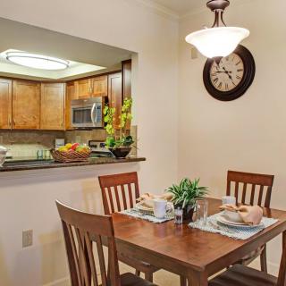 Cozy dining area with a wooden table set and an open view into the kitchen.