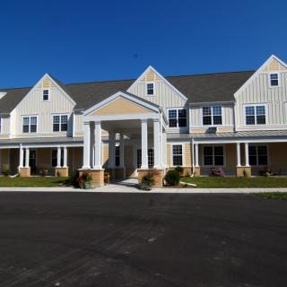 A two-story residential building with a front entrance and peaked roofs.