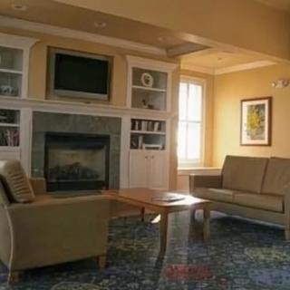 A cozy living room with a fireplace, sofa, armchair, and coffee table.