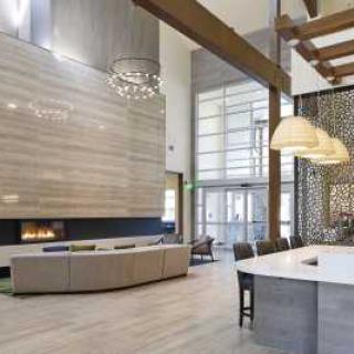 Modern lounge area with high ceilings and a large fireplace.