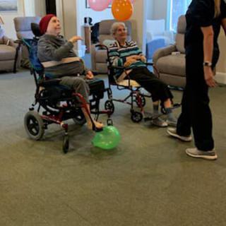 Elderly individuals enjoying a social activity in a community care setting.