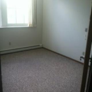 An empty room with a carpeted floor and window.